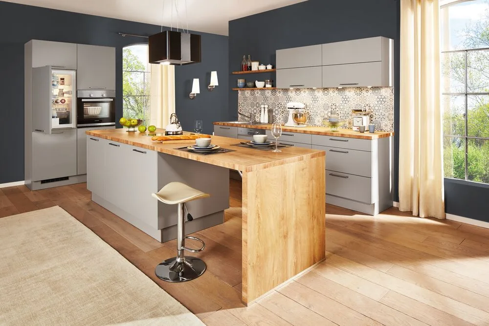 Graue Küche mit Kochinsel und Arbeitsplatte in Holzoptik, Barhocker